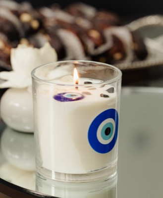 A lit candle with an evil eye motif — Yasmeen Artisan